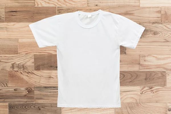 T-shirt branca em branco sobre fundo textura de madeira — Fotografia de Stock