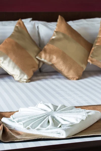 Close up of nice towels on white bed sheet with golden pillow — Stock Photo, Image