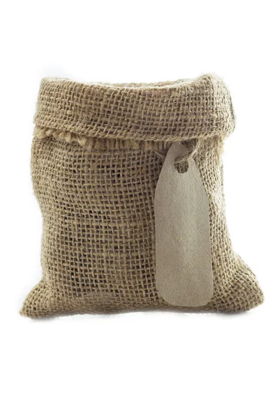 Empty textile burlap sack with blank tag — Stock Photo, Image