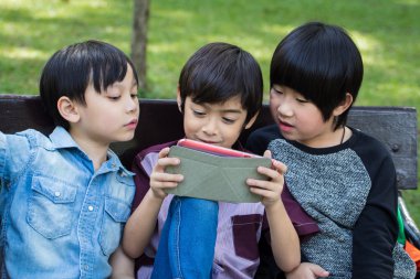 Üç küçük yakışıklı çocuk iPad tablet üzerinde seyir ve oyun oynama