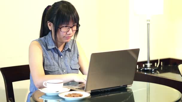 노트북에 그녀 작품과 가정에서 자에 앉아 안경을 착용 하는 아시아 여자 — 비디오