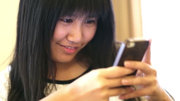 Happy asian woman using cell phone at home — Stock Video