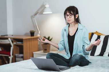 Sakin bir kadın laptopla meditasyon yapıyor, iş konseptinde stres yok, düşünceli barışçıl iş kadını ya da iş yerinde nefes alma egzersizi yapan öğrenci, ev ofisinin meditasyonu.