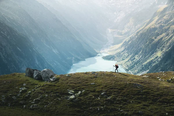在奥地利Zillertal阿尔卑斯山脉 一位女性攀登者在青绿色的蓝色湖面的山脊上攀爬 美丽的景象让人眼花缭乱 年轻的女人走在山边 生活方式 徒步旅行 — 图库照片