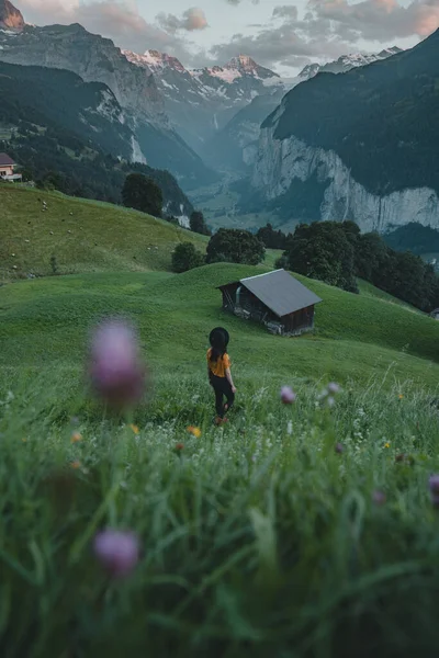 夕阳西下 在劳特布鲁南山谷上空 就像在瓦西里看到的那样 在瑞士 年轻女子一边散步一边欣赏着白雪覆盖的群山 — 图库照片