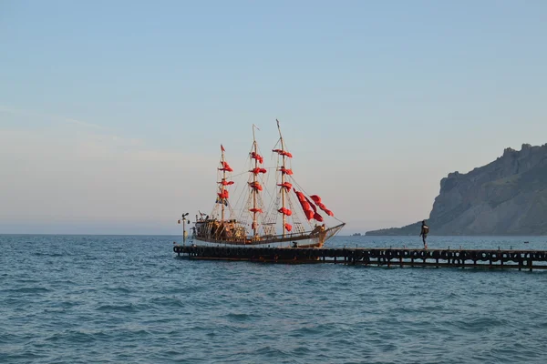 Boat with red sails on the sea shore — Stock Photo, Image