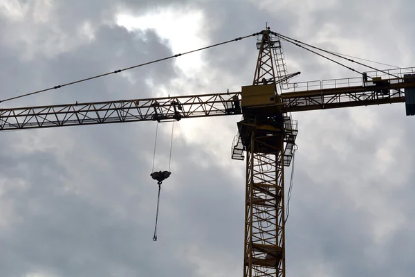 Construction crane lifts materials to the object under construction — Stock Photo, Image