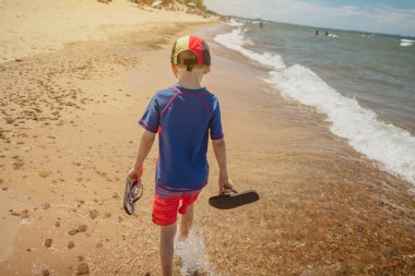 Indiana Dunes Ulusal Parkı 'nda batı sahilinde yürüyen bir çocuk..