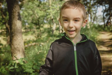 Indiana Dunes Eyalet Parkı 'ndaki kumul patikası boyunca ormanda yürüyüş yapan bir çocuk..