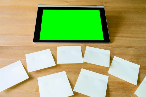 Workplace with tablet pc - green box - and several sticky notes — Stock Photo, Image