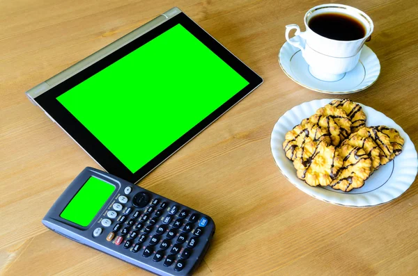 Workplace with tablet pc - green box, calculator, cup of coffee — Stock Photo, Image