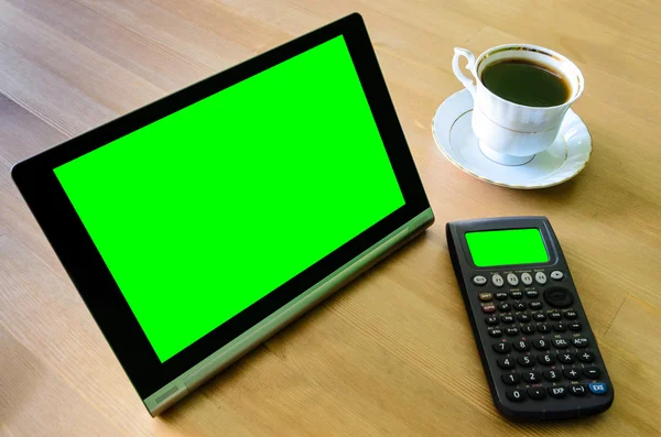 Workplace with tablet pc - green box, calculator and cup of coff — Stock Photo, Image