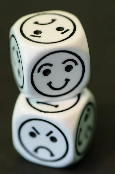 Dice with opposite sad and happy emoticon sides — Stock Photo, Image