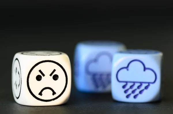 Concetto di triste tempo piovoso emoticon e dadi meteo su blac — Foto Stock