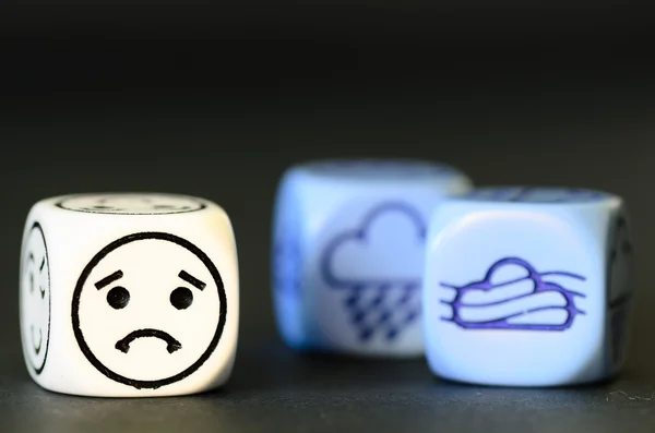 Concetto di triste clima autunnale emoticon e dadi meteo su bla — Foto Stock