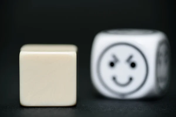 Blank dice with emoticon dice (happy) in background — Stock Photo, Image
