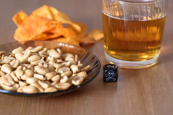 Ungesunde Snacks auf dem Tisch mit Totenkopfwürfeln — Stockfoto