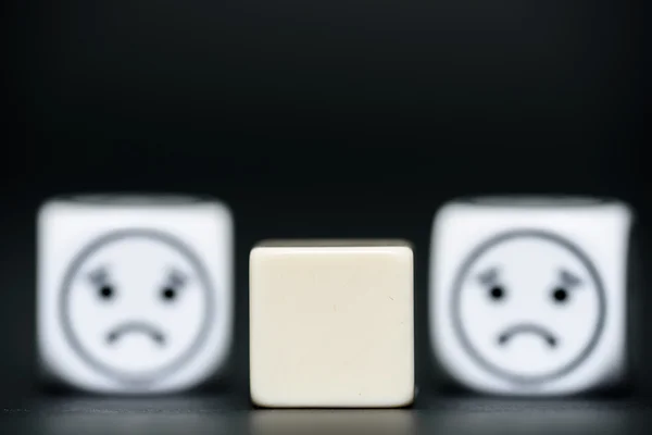 Blank dice with emoticon dice (sad) in background — Stock Photo, Image