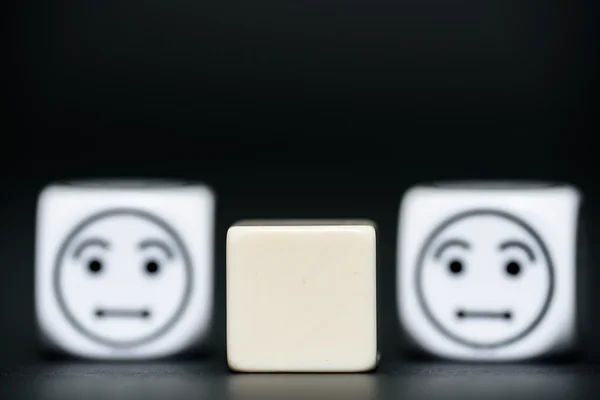 Blank dice with emoticon dice (confused) in background — Stock Photo, Image