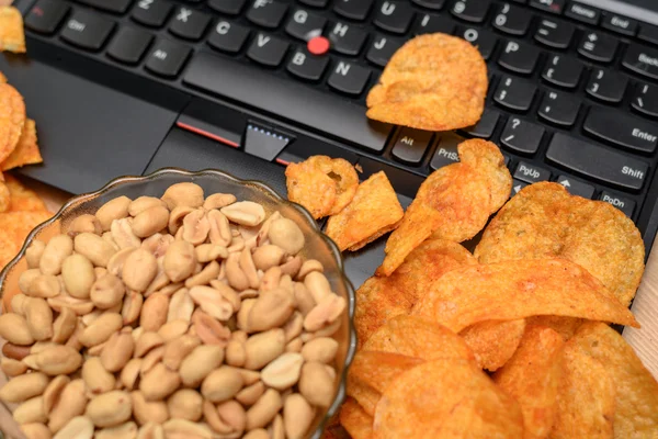 Nahaufnahme eines offenen Laptops mit Chips auf Tastatur und Bogen verstreut — Stockfoto