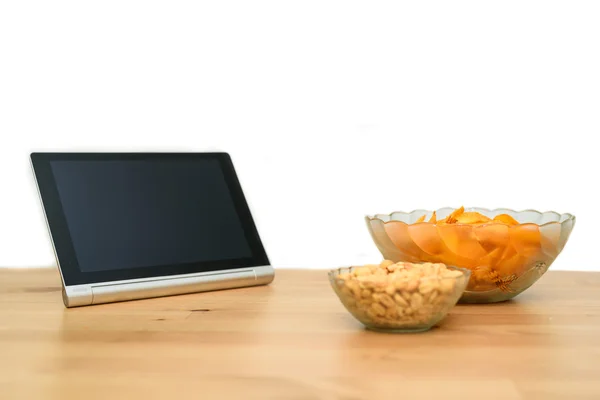 Tablet pc met ongezonde snack geïsoleerd op witte achtergrond — Stockfoto