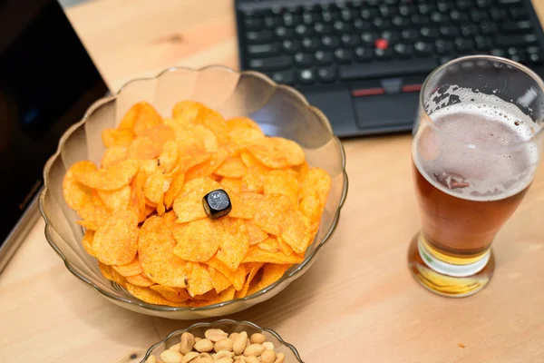 Nahaufnahme von ungesundem Snack und Bier mit Laptop im Hintergrund — Stockfoto