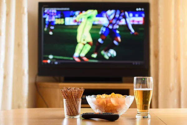 television, TV watching (football, soccer match) with snacks lyi