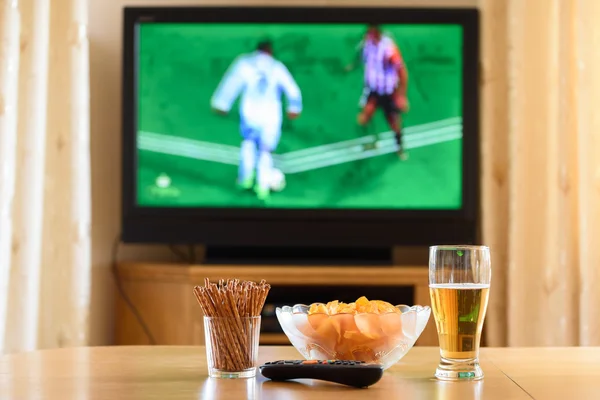 television, TV watching (football, soccer match) with snacks lyi