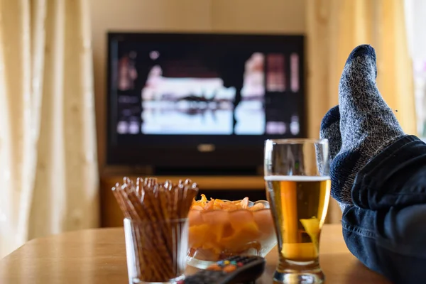 Television, TV watching (movie) with feet on table and huge amou