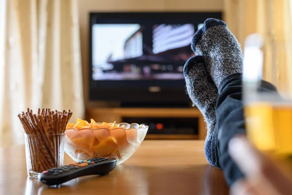 Télévision, regarder la télévision (film) avec les pieds sur la table et amou énorme — Photo