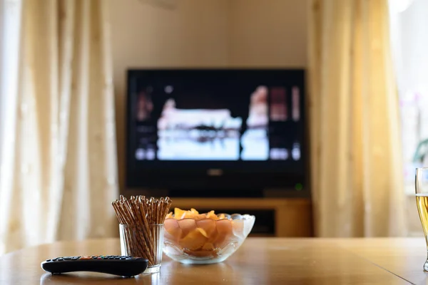 Televisión, televisión viendo (película) con bocadillos tumbados en la mesa Imágenes De Stock Sin Royalties Gratis