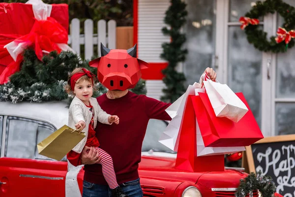 Kırmızı Boğa Maskeli Genç Bir Adam Küçük Bir Bebek Tutuyor — Stok fotoğraf