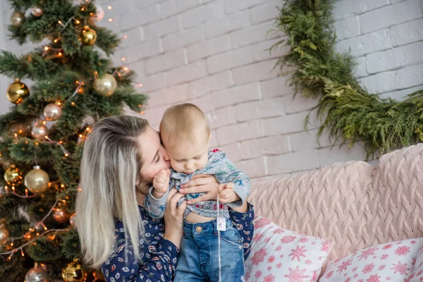 Una Hermosa Joven Sienta Sofá Con Niño Cerca Del Árbol — Foto de Stock