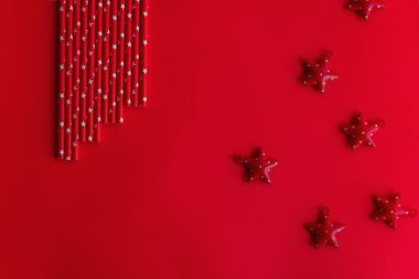 Kırmızı homojen izole bir arka planda yıldızların arasında Yeni Yıl tüpleri bulunur. 2021 numaralı Noel kartı için Noel arkaplanı. Mesaj için yer. Uzayı kopyala, üst görünüm. Düzen düzlemi