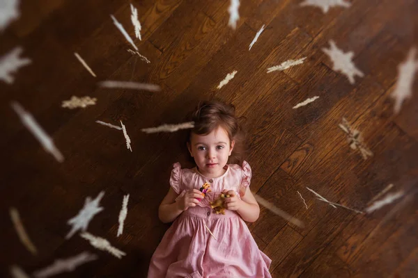 Little Beautiful Girl Pink Dress Lies Wooden Floor Holds Small — Stock Photo, Image