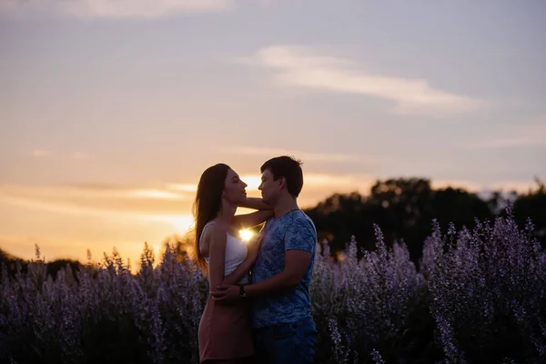 幸福的情侣在爱情的怀抱中 在夕阳西下 在盛开的圣坛前亲吻 一个年轻人热情洋溢地望着眼睛 双手牵着一个漂亮的姑娘 情侣们春季周末旅行 复制空间 — 图库照片