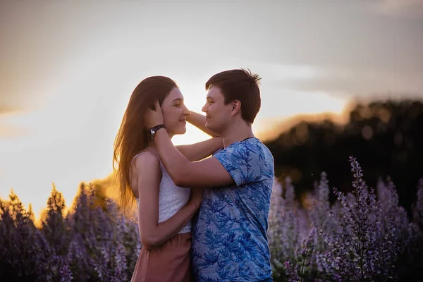 Lyckliga Par Kärleksfulla Kramar Kyssar Vid Solnedgången Nära Ett Blommande — Stockfoto