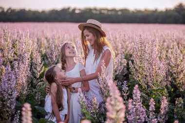 Genç anne, mor bir adaçayı tarlasında iki kızını kucaklıyor. Saman şapkalı, beyazlar içinde. Kadınlar sevgiyle kızlara sarılır, okşar, öperler. Şehir dışında yürüyüşler, hafta sonu seyahatleri. Boşluğu kopyala