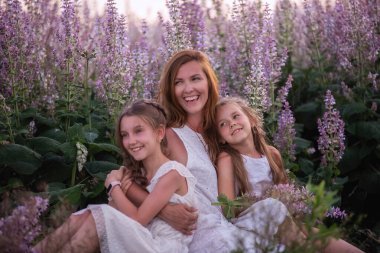 Genç anne, mor bir adaçayı tarlasında iki kızını kucaklıyor. Saman şapkalı, beyazlar içinde. Kadınlar sevgiyle kızlara sarılır, okşar, öperler. Şehir dışında yürüyüşler, hafta sonu seyahatleri. Boşluğu kopyala