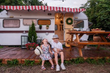 Oğlan ve kız, ahşap zemindeki karavan evinde ellerinde tüylü tavşancık tutarak eğleniyorlar. Erkek ve kız kardeş güler, hasır şapkalar atar, evcil tavşanla oynar, pikniğe gider.