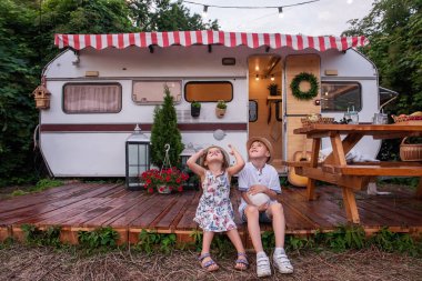 Oğlan ve kız, ahşap zemindeki karavan evinde ellerinde tüylü tavşancık tutarak eğleniyorlar. Erkek ve kız kardeş güler, hasır şapkalar atar, evcil tavşanla oynar, pikniğe gider.