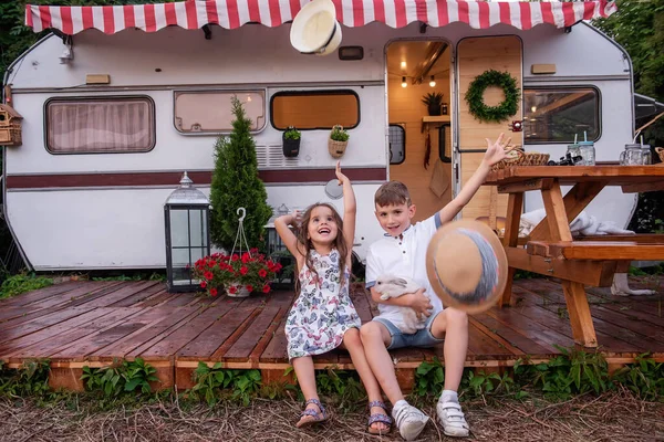 Oğlan ve kız, ahşap zemindeki karavan evinde ellerinde tüylü tavşancık tutarak eğleniyorlar. Erkek ve kız kardeş güler, hasır şapkalar atar, evcil tavşanla oynar, pikniğe gider.