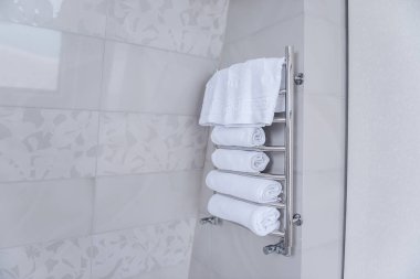 Demir metal kurutma makinesinde duş için beyaz terry havlular var. Hijyen, temizlik kavramı. Banyoda mermer fayanslar var. Moda, modaya uygun bir iç mekan. Boşluğu kopyala
