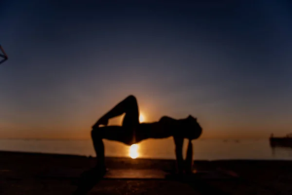 Desfocado Jovem Loira Sportswear Realiza Asanas Ioga Exercícios Praia Nascer — Fotografia de Stock