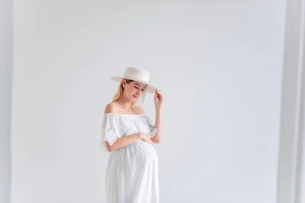Mujer Embarazada Joven Anticipación Bebé Con Sombrero Blanco Vestido Abraza —  Fotos de Stock