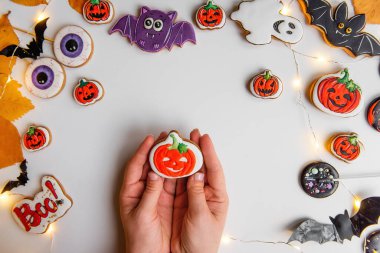 Turuncu kabak şeklinde zencefilli kurabiyenin kremayla nasıl çizileceği konusunda adım adım talimatlar. Dördüncü adım, yolu turuncu ve yeşil kremayla doldur. Cadılar Bayramı tatlıları izole bir arka planda yatıyor