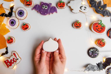 Turuncu kabak şeklindeki zencefilli kurabiyenin kremayla nasıl çizileceği konusunda adım adım talimatlar. Adım 2, balkabağı şeklini beyaz kremayla kapla. Soyutlanmış arka planda Cadılar Bayramı tatlıları