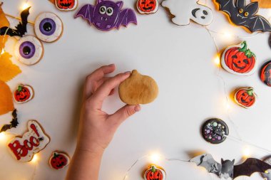 Turuncu kabak şeklinde zencefilli kurabiyenin kremayla nasıl çizileceği konusunda adım adım talimatlar. Birinci adım, elinde zencefil hamuru şeklinde bir balkabağı yatıyor. Beyaz izole arka planda Cadılar Bayramı tatlıları