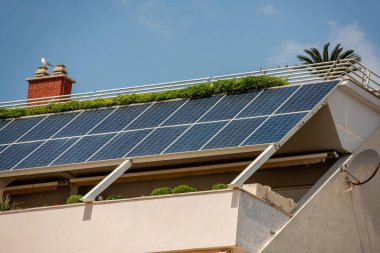 Güneş panelleri çağdaş bir binanın çatısına kurulur, sürdürülebilir elektrik üretir ve daha temiz bir çevre için yeşil teknoloji sergilenir