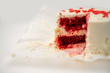 Kırmızı kadife pasta, kremalı beyaz krema ve kırmızı serpiştirme, zengin kırmızı sünger ve krem peynir katmanları ortaya çıkarmak için dilimlenmiş, çöküş, şenlikli tatlı sahnesi için